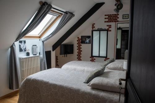 a bedroom with two beds and a window at Les chambres du Bocage - Chambre Marylin in Bressuire