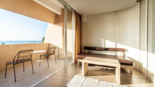 a living room with a table and chairs and a window at Bangsaen Villa in Bangsaen