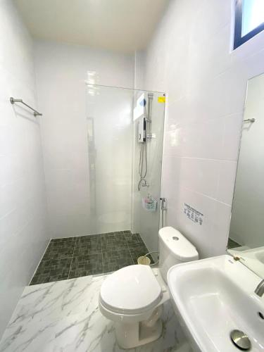a bathroom with a shower and a toilet and a sink at Lantara resort in Ko Lanta