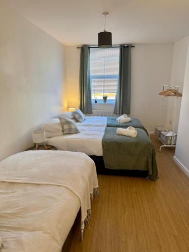 a bedroom with two beds and a window at Charming 6 Bed Flat in Bedminster - Sleeps 8 in Bristol