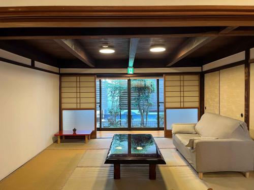 a living room with a couch and a table at ゲストハウス あしもり in Okayama
