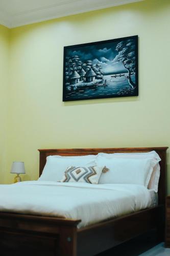 a bedroom with a bed with a picture on the wall at Eternal shine serenity in Munyonyo