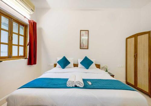 a bedroom with a large white bed with blue pillows at Palette Susegad I 3BHK Apartment I Pool I Candolim I GOA in Candolim