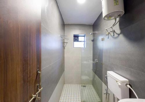 a small bathroom with a shower and a toilet at Palette Susegad I 3BHK Apartment I Pool I Candolim I GOA in Candolim