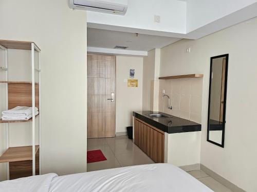 a room with a bed and a sink and a bathroom at Padina Soho And Residence in Kebonbesar