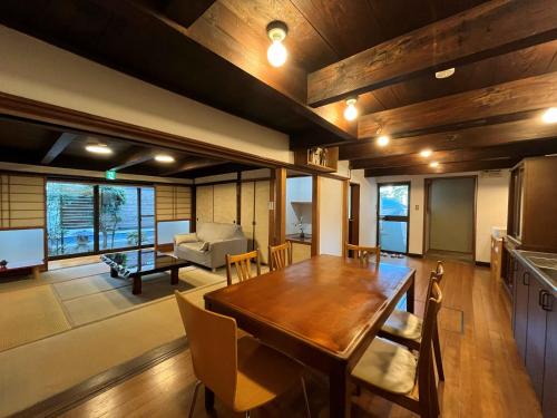 a dining room and living room with a wooden table at ゲストハウス あしもり in Okayama