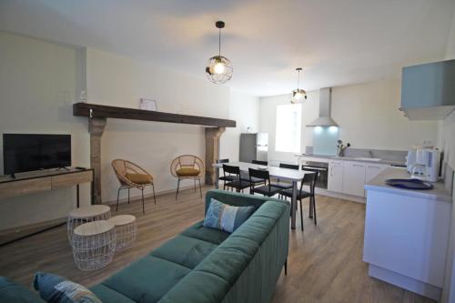 un soggiorno con un divano verde e una cucina di Gîte 87G7451 a Saint-Mathieu