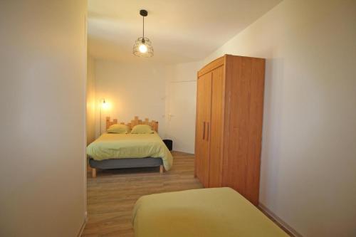 een kleine slaapkamer met twee bedden en een kast bij Gîte Les Champs N°1 in Saint-Mathieu