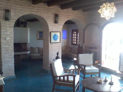 een woonkamer met stoelen en een tafel en een bakstenen muur bij Villa Oceane in Taghazout
