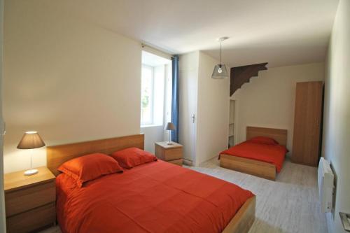 a bedroom with two beds with red sheets and a window at Gîte 87G7452 in Saint-Mathieu