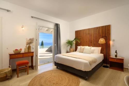 a bedroom with a bed and a door to a balcony at Aether Messonghi - Seaview Collection Corfu in Mesongi