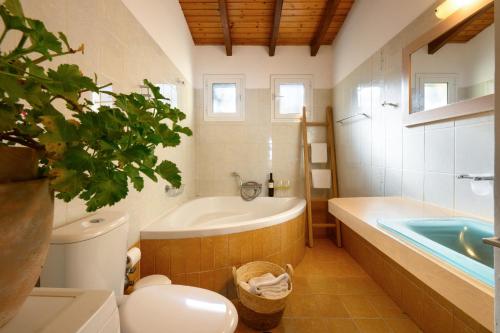 a bathroom with a tub and a toilet and a sink at Aether Messonghi - Seaview Collection Corfu in Mesongi