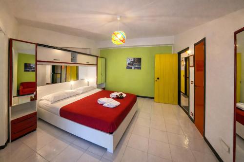 a bedroom with a large bed with a red blanket at LA BAIA DI NETTUNO Il Gatto e La Volpe in Venetico