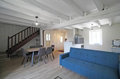 een woonkamer met een blauwe bank en een tafel bij Gîte Les Champs N°4 in Saint-Mathieu