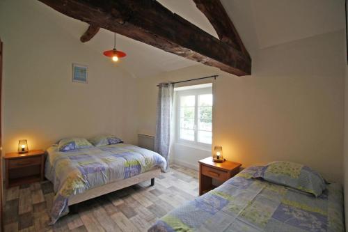 een slaapkamer met twee bedden en een raam bij Gîte Les Champs N°4 in Saint-Mathieu