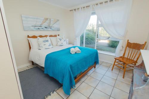 a bedroom with a bed with two shoes on it at Seabreeze in Hermanus