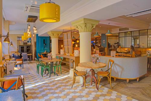 a restaurant with tables and chairs in a room at The Grand Bristol By Sunday in Bristol