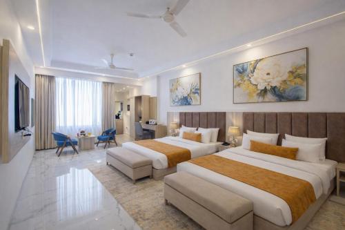 una camera d'albergo con due letti e un soggiorno di Hotel East End Delhi Airport With Free Airport Drop a Nuova Delhi
