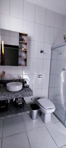 a bathroom with a toilet and a sink and a shower at loft climatizado em Timóteo próximo à Aperam, Ipatinga e Coronel Fabriciano in Timóteo
