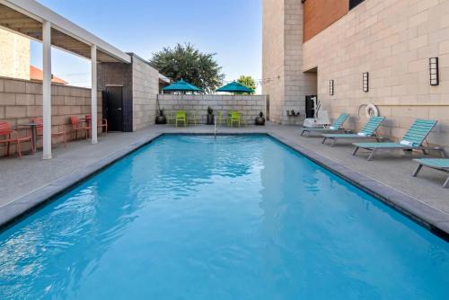 a swimming pool with blue chairs and a building at Home2 Suites By Hilton Dallas Grand Prairie in Grand Prairie
