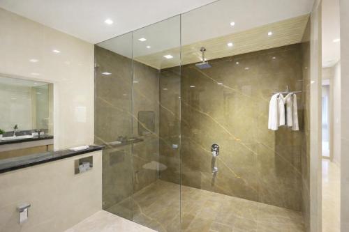 un bagno con doccia con porta in vetro di Hotel East End Delhi Airport With Free Airport Drop a Nuova Delhi