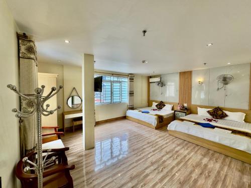 a hotel room with two beds and a television at Văn Phượng Hostel in Cat Ba
