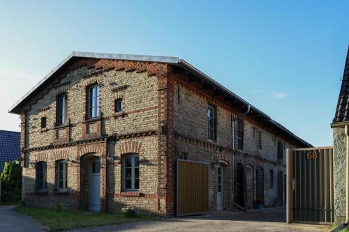 an old brick building with a gate in front of it at Idyllic Hideaway In The Countryside in Marienwerder