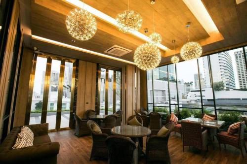 曼谷的住宿－Arte Hotel - SHA Extra Plus，大堂设有桌椅和大窗户。