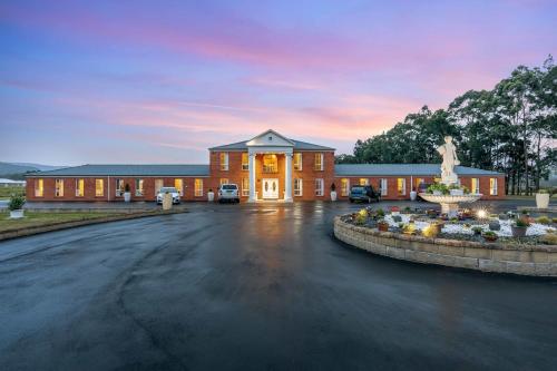 a large brick building with a fountain in front of it at Hunter Valley Family & Pet friendly Self Contained Accommodation in Mulbring