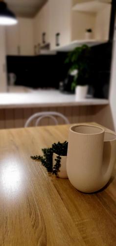 a white cup sitting on top of a wooden table at Hunter Valley Family & Pet friendly Self Contained Accommodation in Mulbring