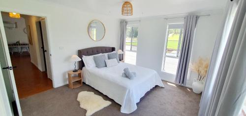 a bedroom with a bed and a large window at Hunter Valley Family & Pet friendly Self Contained Accommodation in Mulbring
