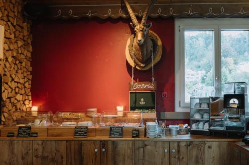 a restaurant with a counter with an animal head on the wall at Alpenblick Weggis - Panorama & Alpen Chic Hotel in Weggis