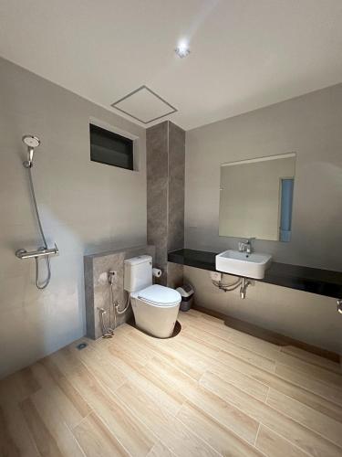 a bathroom with a toilet and a sink at J&P Hotel Sriracha in Ban Laem Chabang
