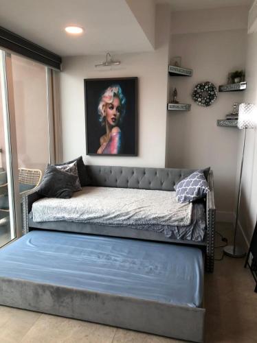 a bed in a room with a painting on the wall at Hermoso apartamento en la playa in Tijuana