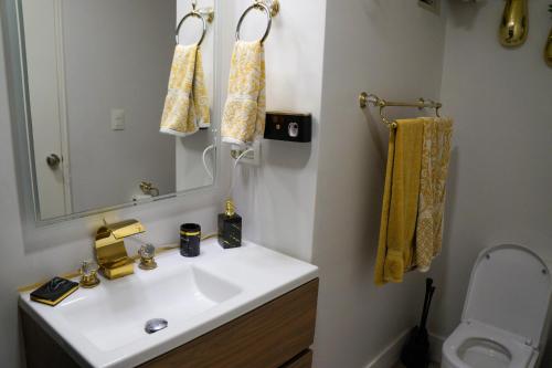 a bathroom with a sink and a mirror and a toilet at Hermoso apartamento en la playa in Tijuana