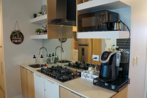 a kitchen with a stove top and a microwave at Hermoso apartamento en la playa in Tijuana