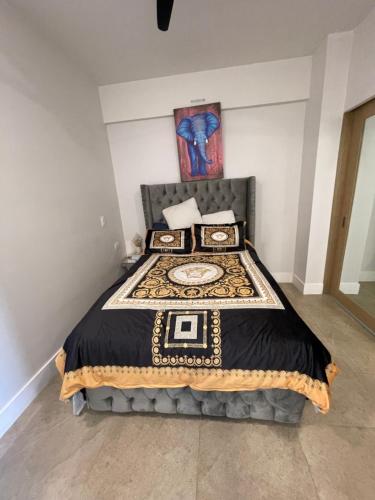 a bedroom with a bed with a black comforter at Hermoso apartamento en la playa in Tijuana