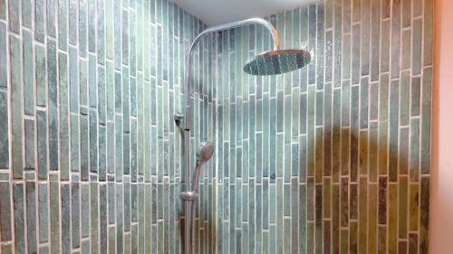 een douche in een badkamer met een glazen wand bij Villa Lingga Puncak in Puncak