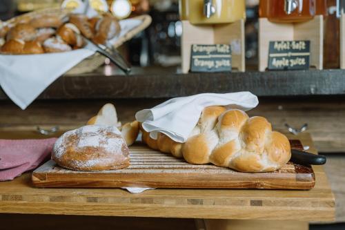 a table with loaves of bread on a cutting board at Alpenblick Weggis - Panorama & Alpen Chic Hotel in Weggis