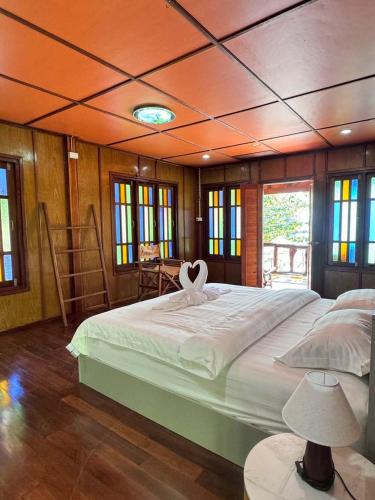 a bedroom with a large bed with a heart on it at Bangalow Coconut corner in Ban Laem Sai