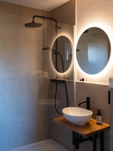 a bathroom with a sink and two mirrors at Berghotel Lindenhof in Siegsdorf
