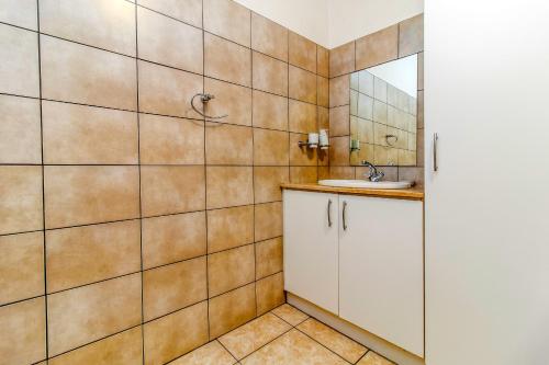 un bagno con lavandino e specchio di Skyline Hideout XL King Bed FREE Parking Views a Edenvale