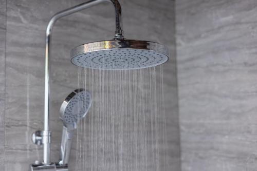 a shower with a shower head in a bathroom at Calma Eco Hotel in Thoddoo