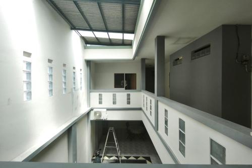 an empty hallway in a building with a ladder at INNCA Singa Utara, Semarang in Alastuwo