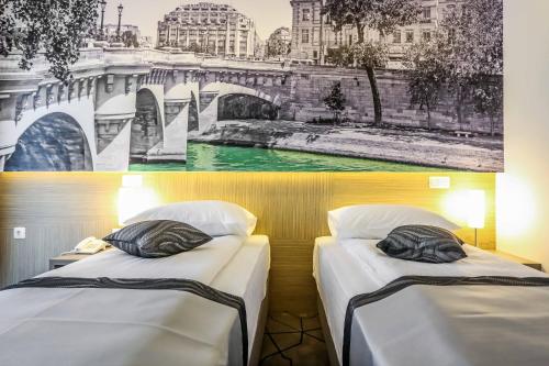 2 camas en una habitación con una foto de un puente en Hotel Grad, en Sarajevo