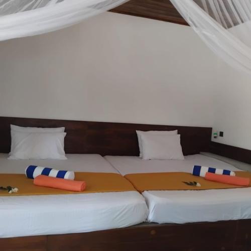 a large bed with two pillows on top of it at Gramatic Cottage Udawalawe in Udawalawe
