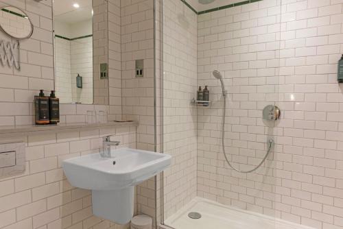 a white bathroom with a sink and a shower at Bristol Grand by Sunday in Bristol