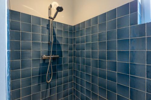 a blue tiled shower with a shower head at Guesthouse de Bovenboer in Nijeveen