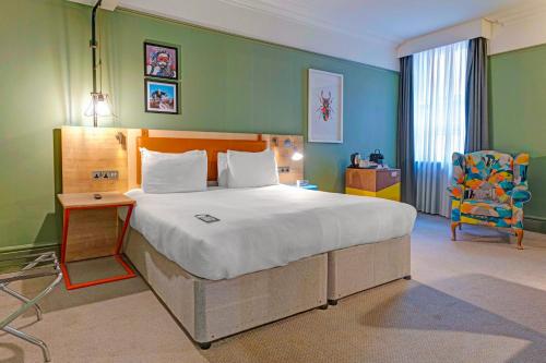 a bedroom with a large bed and a chair at Bristol Grand by Sunday in Bristol