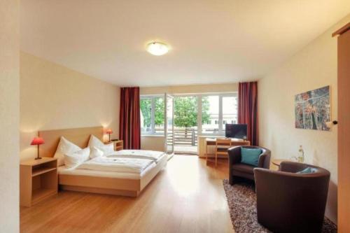 ein Schlafzimmer mit einem Bett, einem Schreibtisch und einem Stuhl in der Unterkunft Bernsteinsee Hotel and Ferien by Palette Resorts in Sassenburg